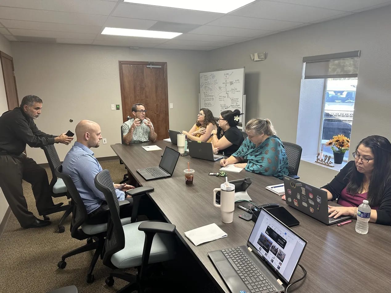 Swiftbuild founders working with Hernando County Development Services staff in a conference room with a whiteboard of development planning notes