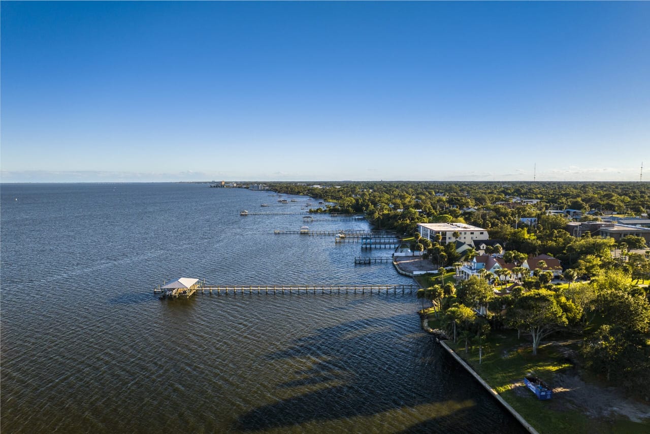 Daytime aerial view of Titusville, Florida showing the Indian River, the bridge crossing it, downtown buildings, and waterfront neighborhoods